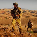 Two Australian soldiers walk through the Afghan desert