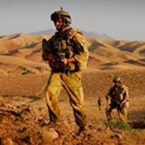Two Australian soldiers walk through the Afghan desert