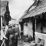 Huts ablaze after Japanese bombs on a village in Sinagpore