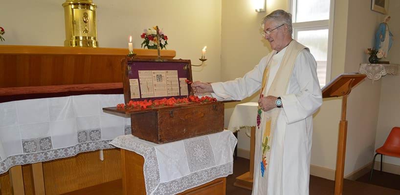 Father Paul Mercovitch laying a poppy on the portable altar, Patchewollock 2015  Diocese of Ballarat