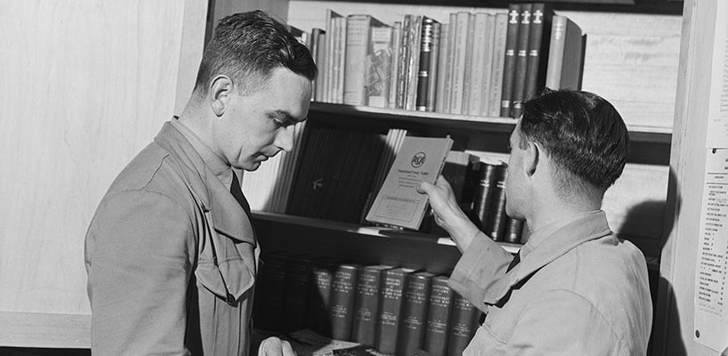 Two RAAF members select publications from the library of the RAAF Educational Service 1944 photographer John Harris Australian War Memorial (VIC1107)