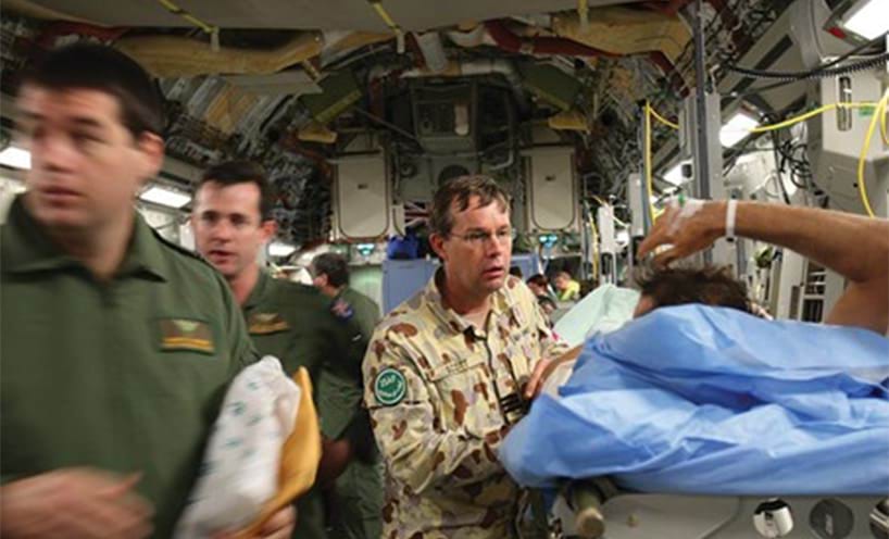 An Australian soldier, attended by Wing Commander David Scott is evacuated using a C-17 Globemaster aircraft.