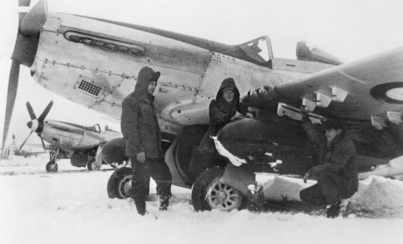 Ground crew of No. 77 Squadron RAAF fitting napalm tanks to P-51 Mustangs.