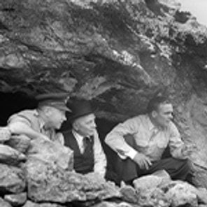 RAAF Flight Lieutenant S. B Prior (left) peers out a well hidden cave which served as headquarters for the Corsican patriots