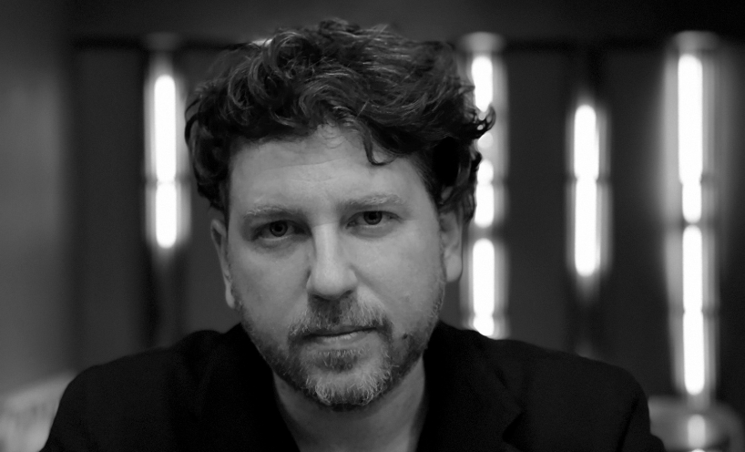 A black and white image of artist László Bordos. He is staring into the camera.
