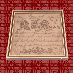 A framed hand-written Christmas letter on a khaki piece of material. The letter says 'Merry Xmas' in decorative font, and the message is written in cursive.