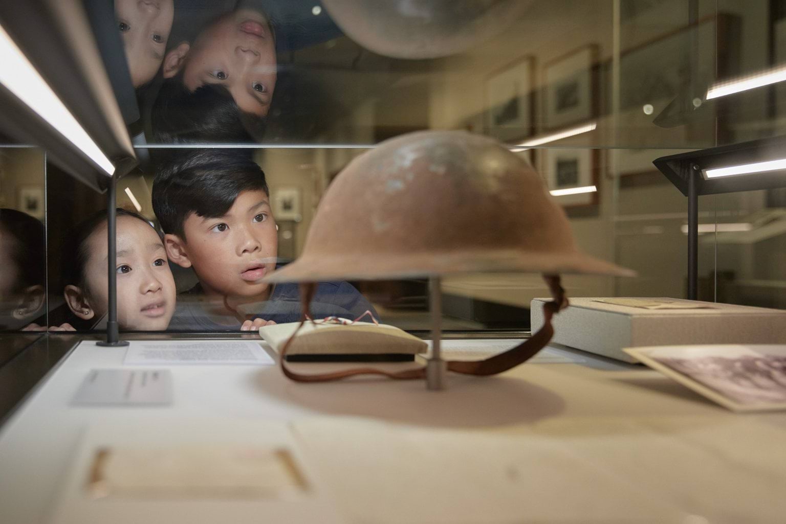 Two children looking at an artifact in a display case at a muesum