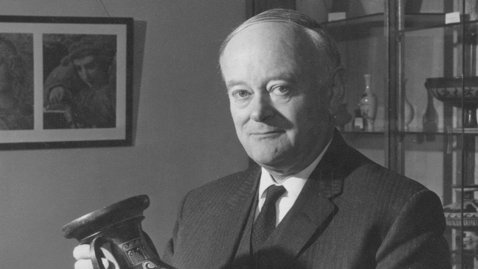 Black and White photograph of Professor A.D. Trendall, standing in an office holding a South Italian vase
